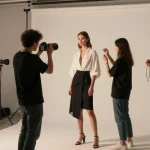 Servizi fotografici moda Milano: modello elegante in studio fotografico con styling e trucco professionale.