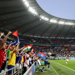 Suasana pertandingan Piala Dunia 2026 dengan fans, pemain, dan statistik di stadion